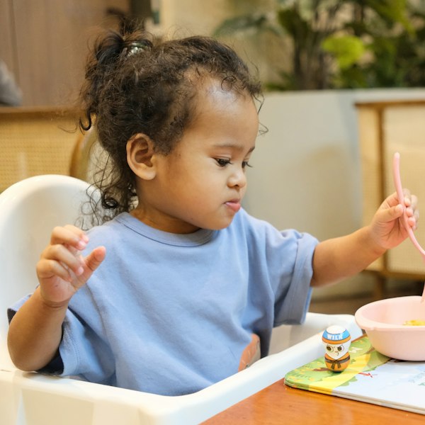 Criança comendo na cadeirinha